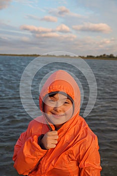 Portrait of little girl on the background of the sky and water