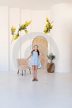 Portrait of a little girl with a bouquet of spring yellow flowers