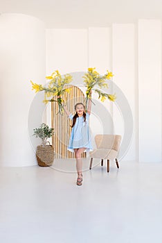 Portrait of a little girl with a bouquet of spring yellow flowers