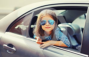 Portrait of little girl child sitting in car as passenger looking out of car window