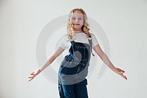 Portrait of a little girl in denim in a white room