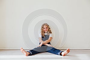 Portrait of a little girl in denim in a white room