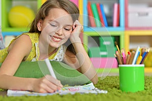 Portrait of little girl drawing in her room