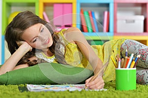 Portrait of little girl drawing in her room