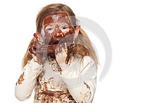 Portrait of a little girl eating chocolate bar and face covered in chocolate