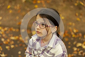 Portrait of a little girl with eyeglasses in autumn park