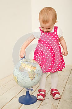 Portrait of little girl with globe in hands, on it
