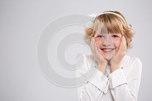 Portrait of a little girl, she is happy and put her hands on her cheeks.