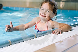 Portrait little girl having fun in indoor swimming-pool
