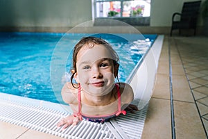 Portrait little girl having fun in indoor swimming-pool