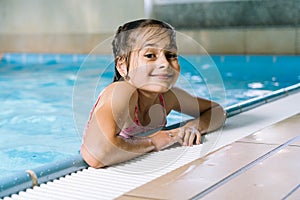 Portrait little girl having fun in indoor swimming-pool