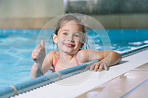 Portrait little girl having fun in indoor swimming-pool