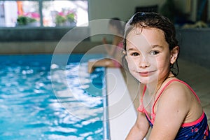 Portrait little girl having fun in indoor swimming-pool