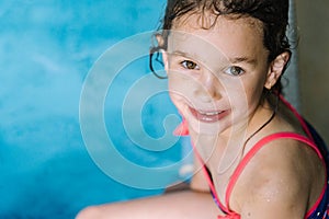 Portrait little girl having fun in indoor swimming-pool