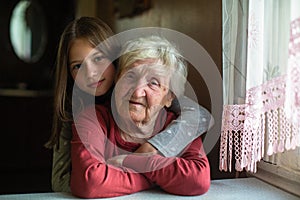 Portrait of little girl and her happy grandmother in his home