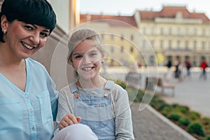 Portrait of little girl with her mother outdoor in city