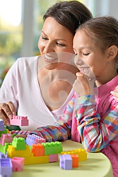 Portrait of little girl and her mother playing