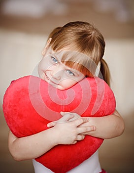 Portrait of little girl holding red heart