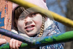 Portrait of a little girl through the iron bars of a staircase