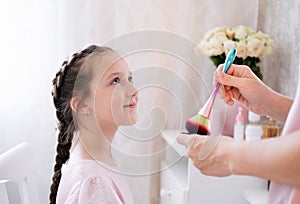 Portrait of little girl making make up