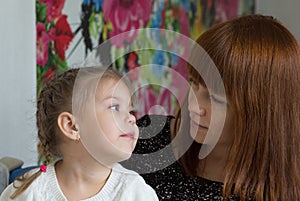 Portrait of little girl and mother looking at each other with soft look