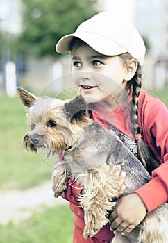 Portrait of little girl outdoors with a dog