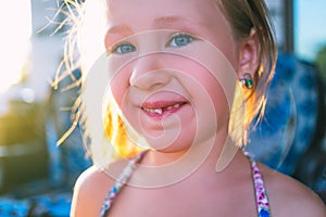 Portrait of a little girl with an outstretched milk tooth