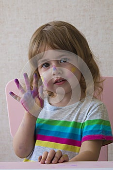Portrait of a little girl with painted palm and face.