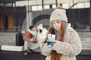 Portrait of a little girl with passports and her parents behind