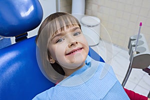 A portrait of a little girl patient in a dental chair in a dentistÃ¢â¬â¢s office photo