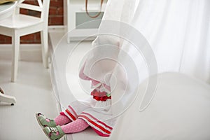 Portrait of little girl peeking from curtains at home