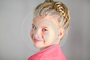 Portrait of a little girl with a pigtail on her photo