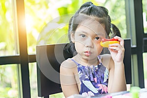 Portrait of little girl playing toy in coffee shop