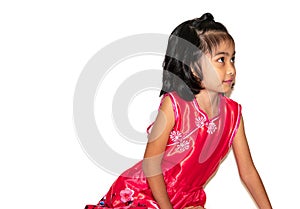 Portrait of a little girl in a red dress sits on the floor and looking up