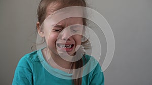Portrait little girl sad upset child burst into tears cries sob looking at camera indoors. sincere children emotions