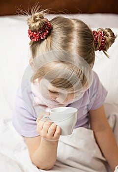 Portrait of a little girl sitting in a bed