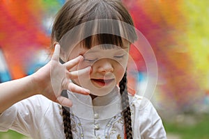 Portrait of little girl smiling on background of the colorful wall