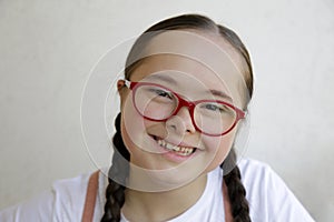 Portrait of little girl smiling on background of the wall