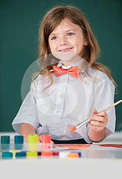 Portrait of little girl smiling happily while enjoying art and craft drawing lesson. Child girl drawing with coloring