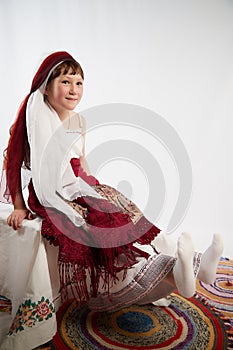 Portrait of Little girl in a stylized Tatar national costume on a white background in the studio. Photo shoot of funny photo