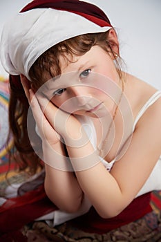 Portrait of Little girl in a stylized Tatar national costume on a white background in the studio. Photo shoot of funny photo