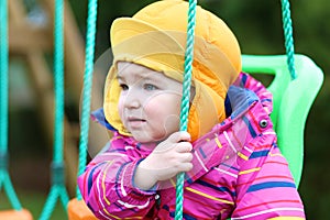Portrait of little girl in swing at winter
