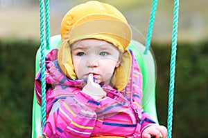 Portrait of little girl in swing at winter