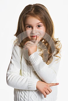 Portrait of little girl thinking, over a gray