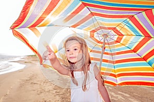 Portrait of a little girl with an umbrella on the beach