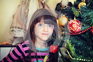 Portrait of little girl under Christmas tree