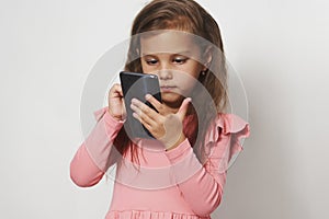 Portrait of a little girl using cell phone against white background