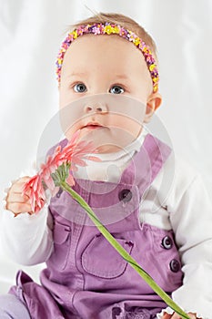 Portrait of little girl in violet pinafore dress with headband photo