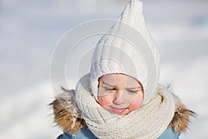 Portrait of little girl in warm knitted wear in winter