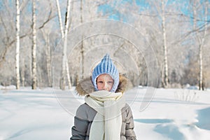 Portrait of little girl in warm wear in outdoors in winter